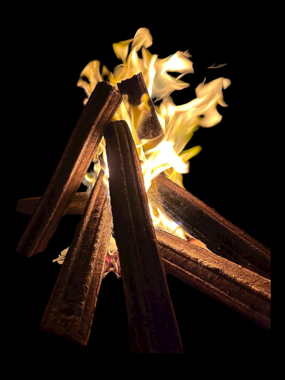 Close-up of burning chocolate sticks against a black background